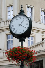 Fototapeta na wymiar Old style street clock with flowers