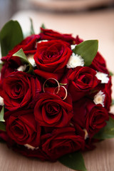 Red roses with wedding rings