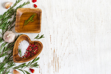 Wooden bowl with olive oil and spices on a white background. Top view with copy space
