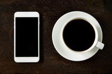 Fototapeta na wymiar cup of coffee and smartphone on the wood