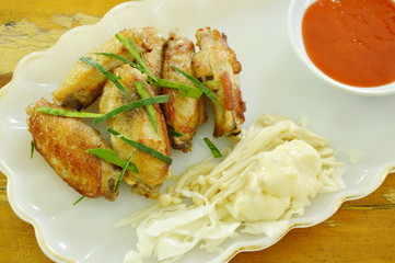fried chicken wing salt and pepper topping slice lemon grass dipping chili sauce on plate