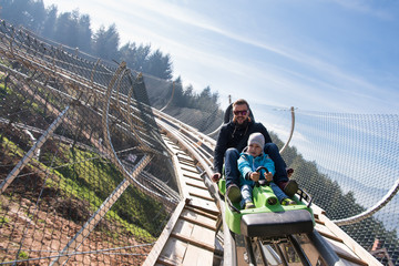 father and son enjoys driving on alpine coaster