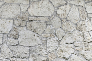 Wall made of natural limestone. Irregular stone surface.