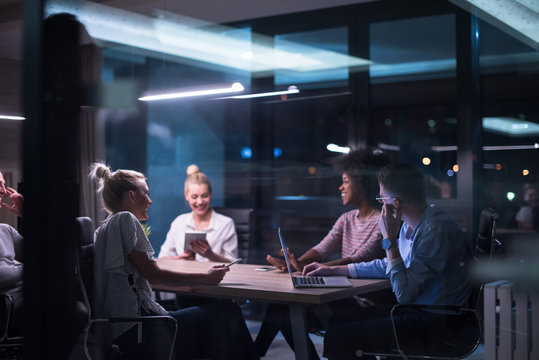 Multiethnic startup business team in night office - Powered by Adobe