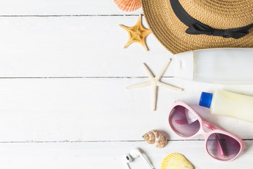 Naklejka premium Beach accessories. Bag, towel, sunglasses and flip-flops on wooden background. Top view with copy space