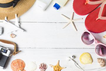 Beach accessories. Bag, towel, sunglasses and flip-flops on wooden background. Top view with copy space