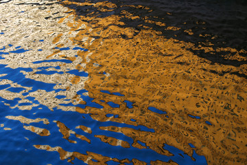 Reflection buildings, illuminated by the sun, in the water.