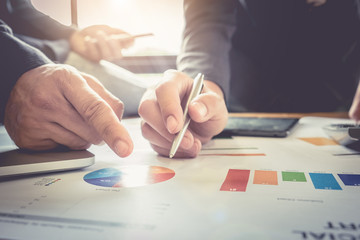 Close up of business man hand pointing at business document on financial paper during discussion at meeting. Group support concept.