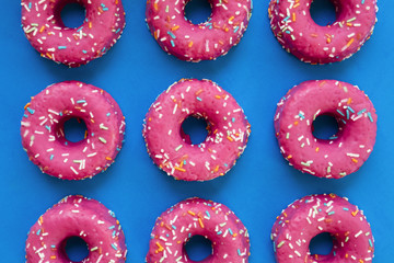 Group of glazed pink donuts on a blue background