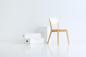 Fototapeta premium Wood chair on white background with white wood boxes and soft reflection on the floor