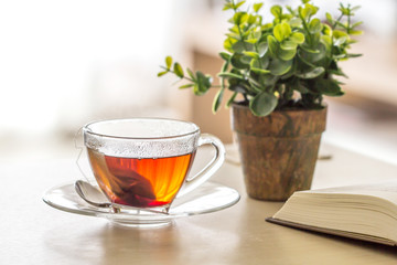 Close up the warm black tea cup on the wooden table in living room , relax with tea time concept