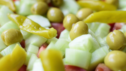 Frischer gesunder Salat mit Gurken, Oliven und Peperoni im close up