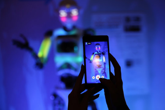 Girl photographes a robot in the dark. Instagram