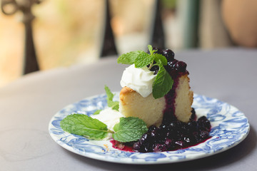 Blueberry cake with blueberry sauce. homemade blueberry cake with whipped cream. fresh blueberry sweet sauce.