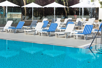 sunbeds and umbrellas by the swimming pool on a sunny day