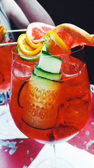Spritz Cocktail with cucumber and red orange on a red table