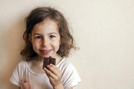 A child in anticipation of a sweet dessert. Chocolate in hand, gourmet smile