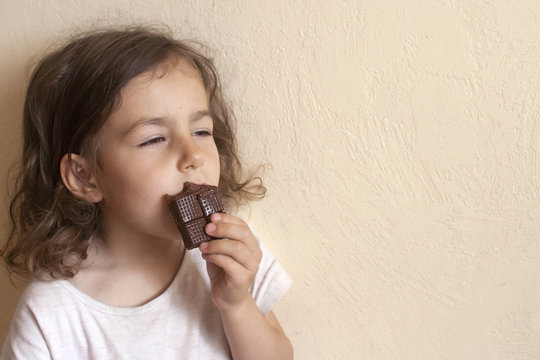 The girl inhales the favorite smell of her milk chocolate