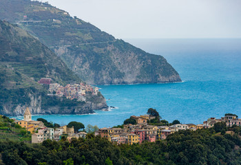 coastal view of famous travel landmark destinations Corniglia and Manarola, small mediterranean old sea town, Cinque terre National Park, Liguria, Italy. Summer daylight clouds