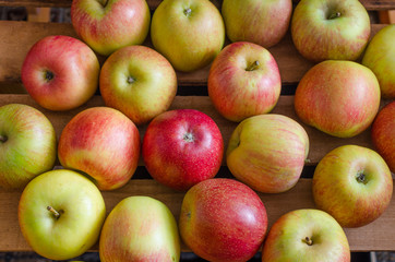 Juicy apples lying in a wooden box.