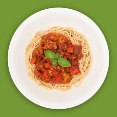 Spaghetti Bolognese on white plate isolated on green background, overhead view