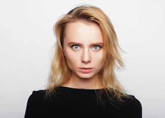 Naklejka premium Portrait of a young woman with blond hair in a black shirt on a 