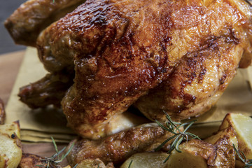 pollo arrosto e patate  su tagliere in legno