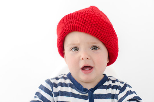 Kid in red hat is indignant two first teeth studio