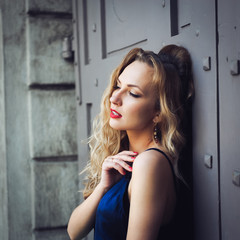 close-up portrait of a young girl hipster beautiful blonde with red lips laughing and posing against the backdrop of the city