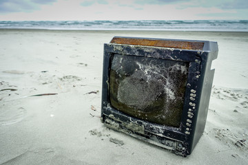 Beach pollution. A rusted and destroyed tv on the beach causing damage to the environment in Muisne Island in Ecuador