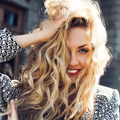 close-up portrait of a young girl hipster beautiful blonde with red lips laughing and posing...