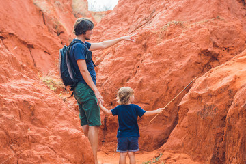 Father and son travelers in red canyon near Mui Ne, southern Vietnam. Traveling with children...