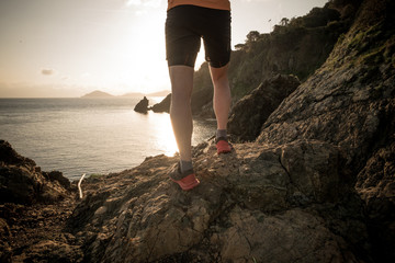 Man ready to run on a rock near the sea