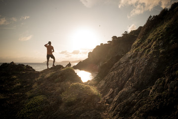 Man ready to run on a rock near the sea