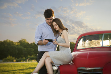 Fototapeta premium the couple in love looking to the mobile phone