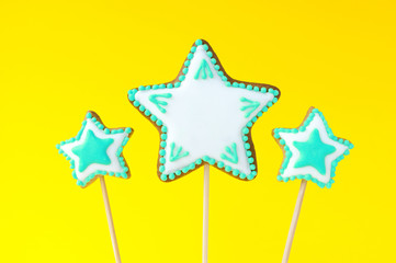 Homemade gingerbreads in the form of turquoise stars on the yellow background. Picture for a menu...