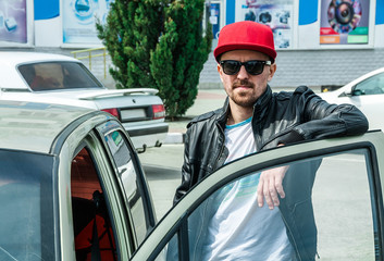 Portrait of a young stylish man in a baseball cap and sunglasses