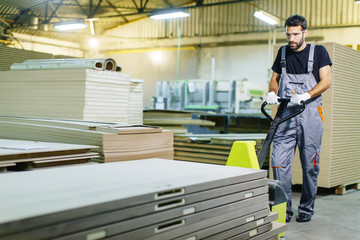 Fototapeta premium Handsome young man working in the furniture factory