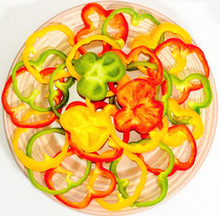 Circles of bell pepper on a ceramic plate on a white background