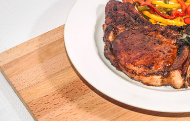 Delicious appetizing steak with vegetables on a plate on a wooden board, free, copyspace