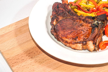 Delicious appetizing steak with vegetables on a plate on a wooden board, free, copyspace
