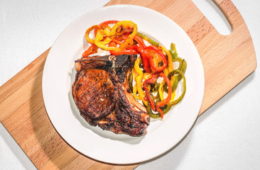 Delicious appetizing steak with vegetables on a plate on a wooden board, free, copyspace