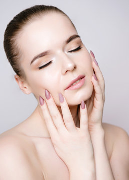 Young girl with clean skin without make-up and pink manicure