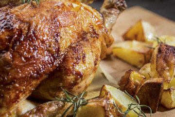 Dettaglio di pollo cotto alla brace con rosmarino e patate
