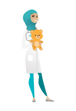 Pediatrician doctor holding teddy bear.