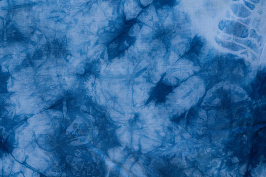 Pattern of blue tie batik dye on cotton cloth, Dyed indigo fabric background and textured, Painted blue watercolor on white cotton cloth