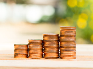 Four rows of rising growth golden stack coins with green nature background. Growing and saving money concept.