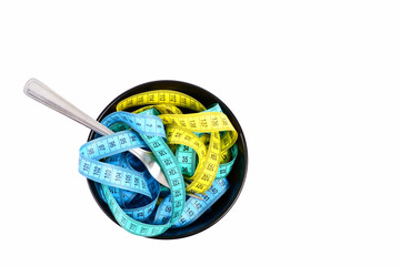 Composition of measuring tapes in different colors put in bowl