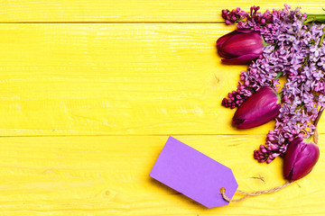 Bunch of spring tulips and lilac with purple note label