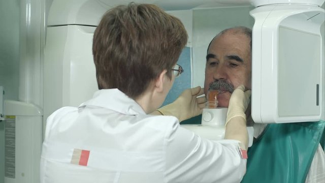 Dental senior patient undergoes panoramic skull scan of teeth
